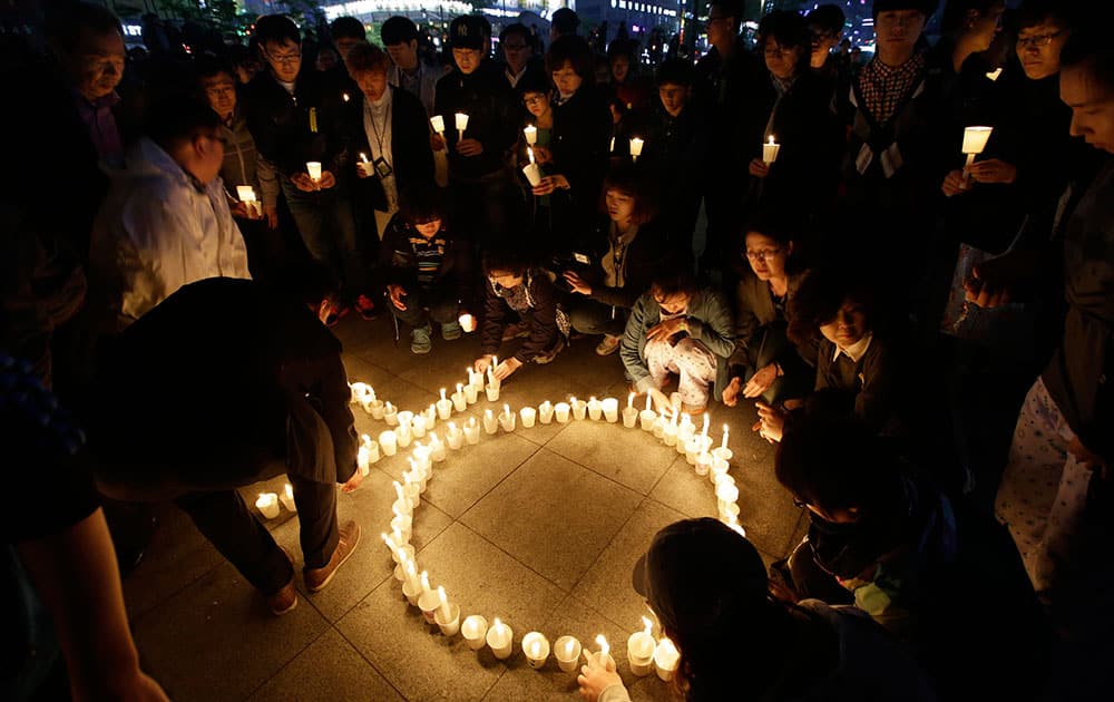 People place candles during a candlelight vigil for the safe return of passengers of the sunken ferry Sewol in Ansan, South Korea.