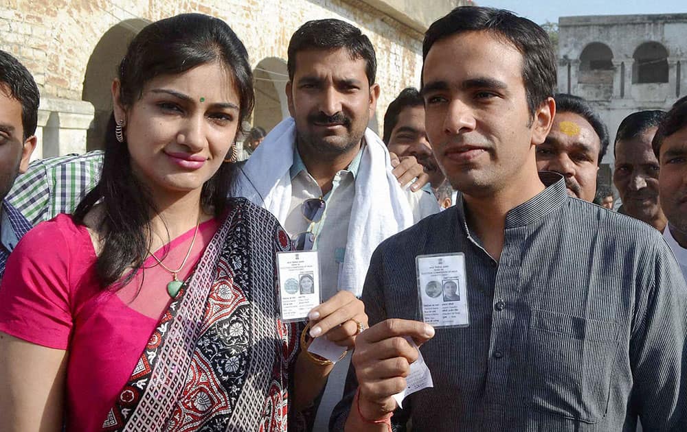 Rashtriya Lok Dal (RLD) candidate Jayant Chaudhary and his wife Charu show their voter identity card before casting votes for Lok Sabha elections in Mathura.