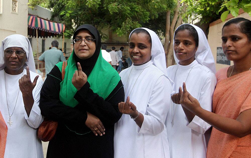 A Muslim woman along with Christian nuns showing inked fingers after casting votes for Lok Sabha election, in Chennai.