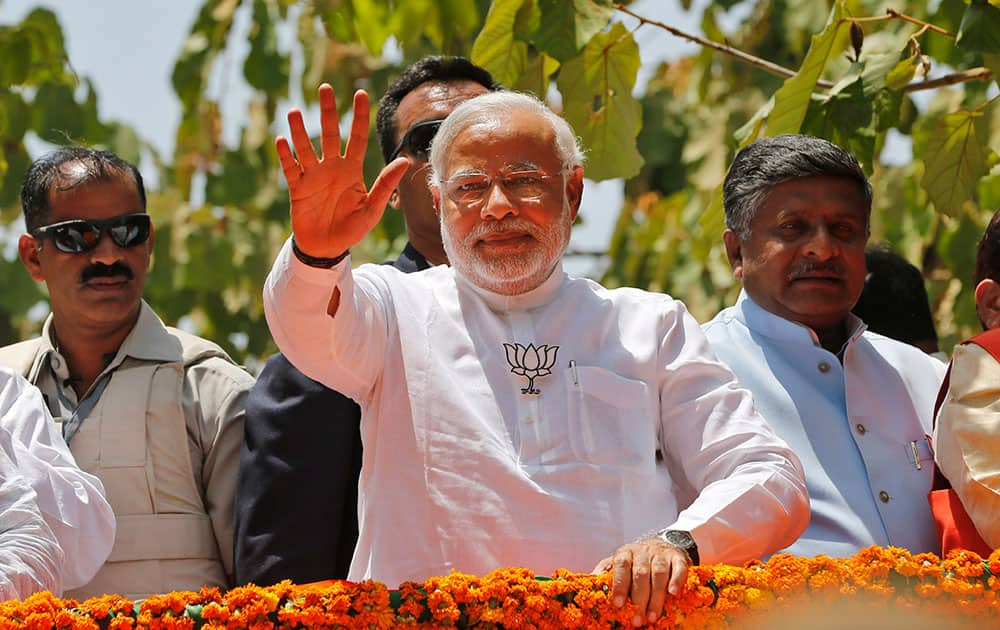 Bharatiya Janata Party (BJP) `s prime ministerial candidate Narendra Modi, waves to supporters as he arrives in an open vehicle to file his nomination in Varanasi.