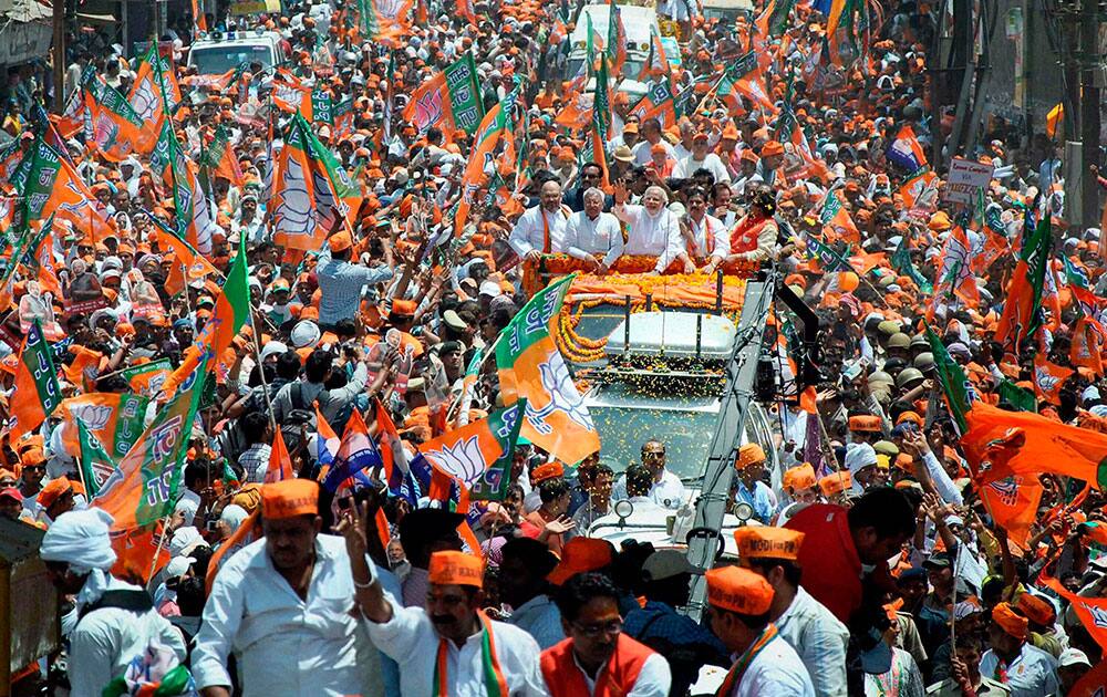 BJP Prime Ministerial candidate Narendra Modi waves at supporters during a road show before filing his nomination papers in Varanasi.