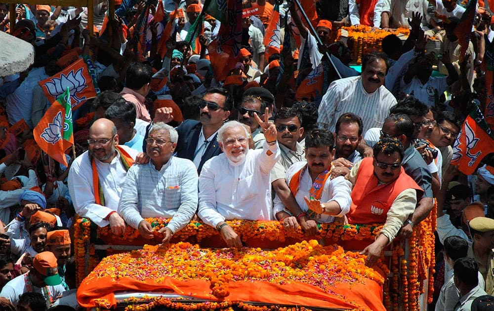 BJP Prime Ministerial candidate Narendra Modi waves at supporters during a road show before filing his nomination papers in Varanasi.