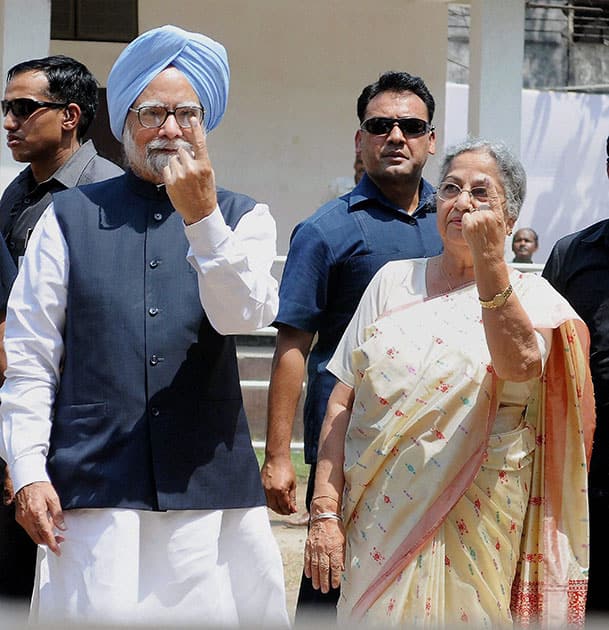 Prime Minister Manmohan Singh and his wife Gursharan Kaur showing the ink mark on their fingers after casting votes for Lok Sabha polls at Dispur in Assam.