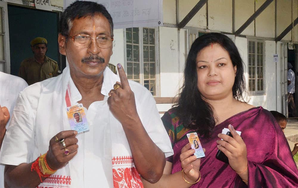 BJP candidate from Nagaon constituency Rajen Gohain with his wife shows their inked fingers after casting their votes for Lok Sabha polls, in Nagaon district of Assam.