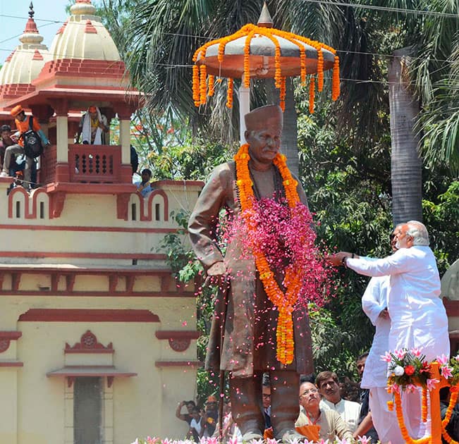 BJP Prime Ministerial candidate Narendra Modi waves at supporters while paying floral tributes to Pt. Madan Mohan Malviya before filing his nomination papers in Varanasi.