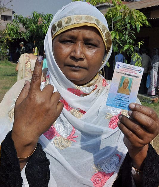 A woman shows her inked finger after casting her vote for Lok Sabha polls at a polling station, in Guwahati.