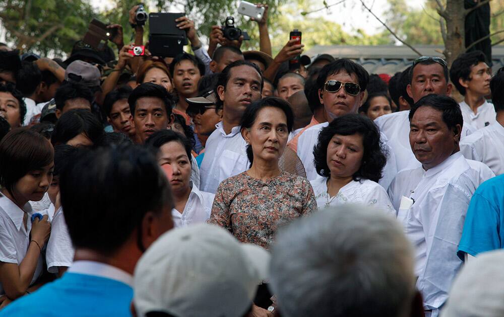 Myanmar opposition leader Aung San Suu Kyi stands along with members of her National League for Democracy (NLD) party during the funeral of Win Tin, a senior leader of her party, at Ye-Way cemetery in Yangon, Myanmar.