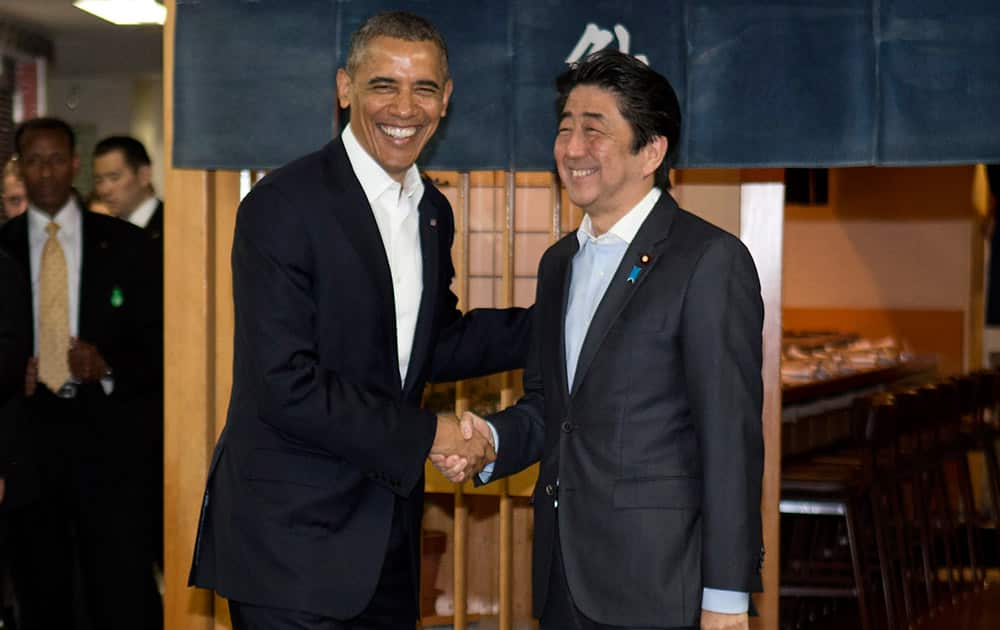 President Barack Obama and Japanese Prime Minister Shinzo Abe shake hands before having dinner at Sukiyabashi Jiro sushi restaurant in Tokyo.