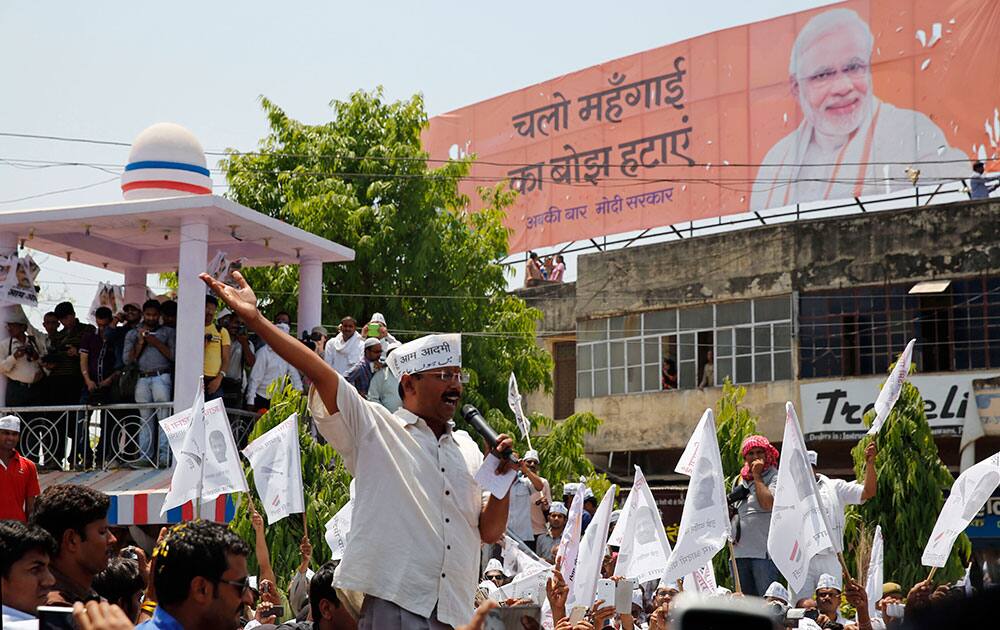 Leader of the Aam Aadmi Party (AAP), or Common Man’s Party, Arvind Kejriwal addresses supporters before filing his nomination, as a giant billboard of Hindu nationalist Bharatiya Janata Party’s prime ministerial candidate Narendra Modi stands in the background, in Varanasi, in the northern Indian state of Uttar Pradesh.