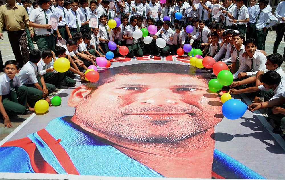 School children greet Sachin Tendulkar on the eve of his birthday in Moradabad.