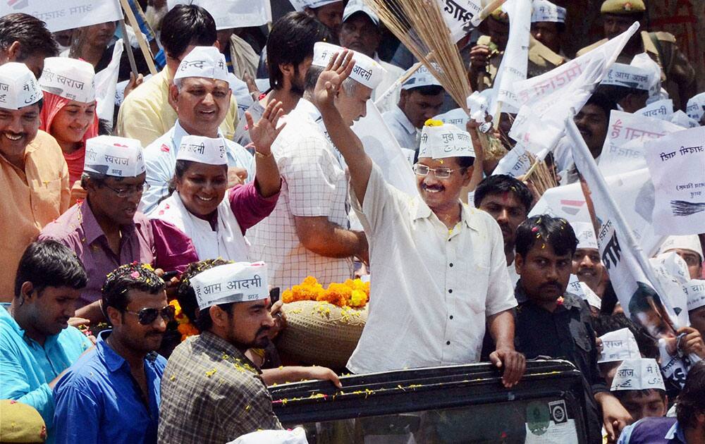 AAP convener Arvind Kejariwal waves to supporters at a roadshow before filing his nomination papers in Varansi.