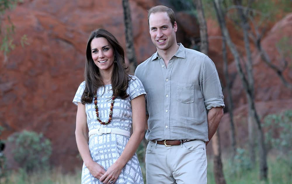 Britain`s Prince William, right, and his wife Kate, the Duchess of Cambridge, pose for photos on the Kuniya walk at Uluru, Australia.
