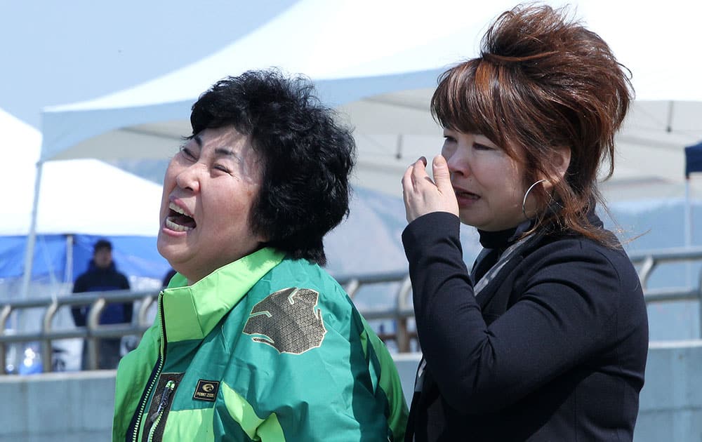 Relatives of a passenger aboard the sunken ferry Sewol weep as they wait for their missing loved one at a port in Jindo, South Korea.