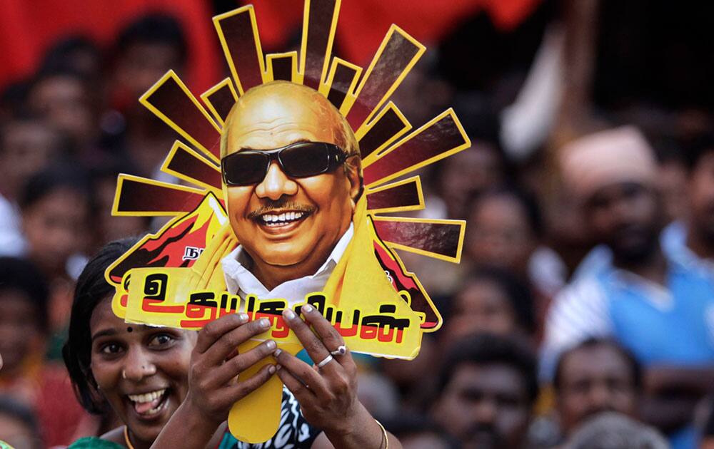 A supporter holds up a cutout with a portrait of Dravida Munnetra Kazhagam (DMK) party chief M. Karunanidhi during an election rally in Chennai, India.