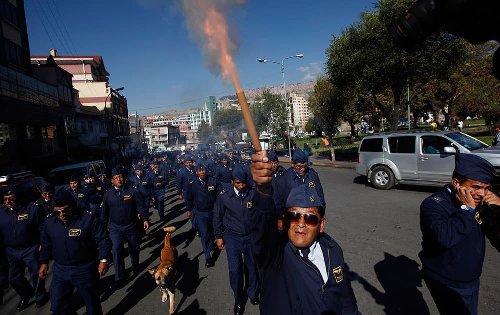 An older member of the Air Force launches a fire cracker during a protest in La Paz, Bolivia.