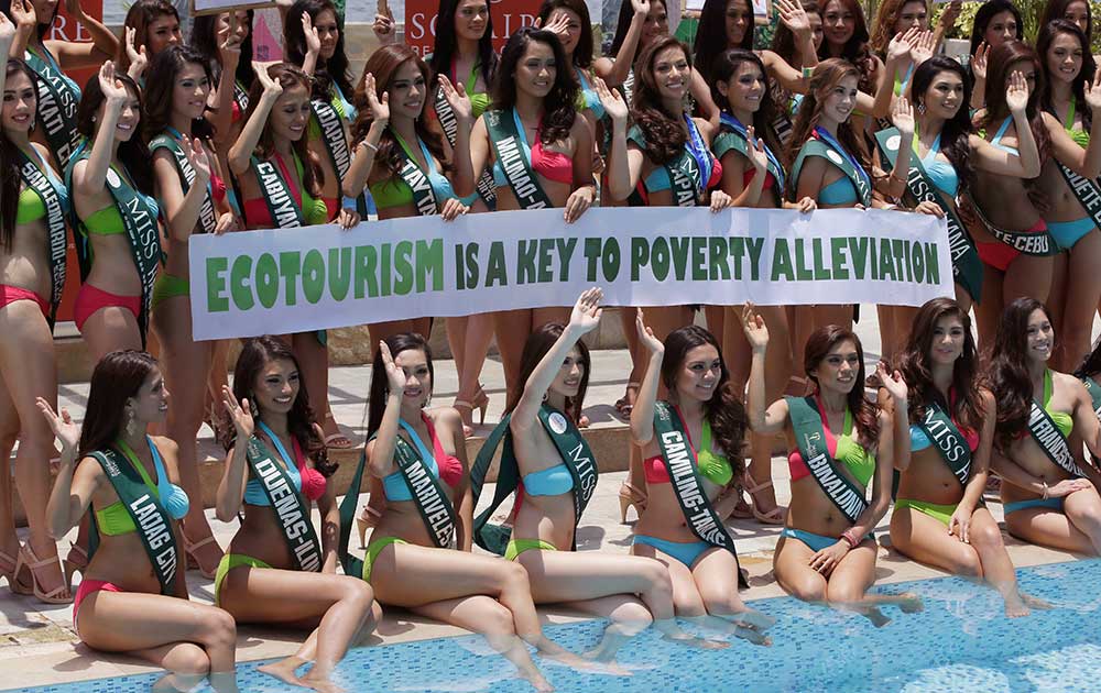 Candidates for the Miss Earth 2014 Philippines beauty pageant display an Earth Day message by the poolside of a hotel-casino in suburban Pasay city, south of Manila, Philippines.