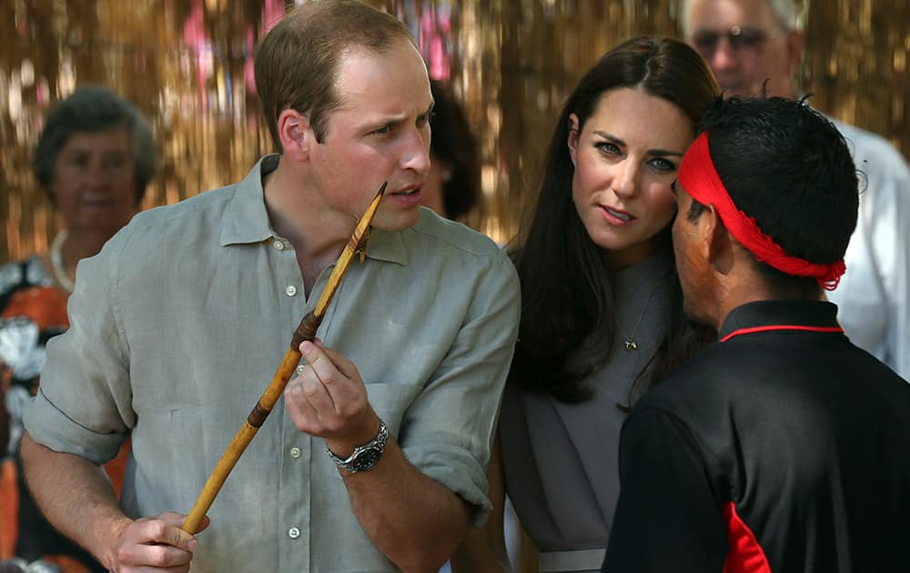 Britain`s Prince William holds a ceremonial spear given to him as he and his wife Kate, the Duchess of Cambridge, listen to a man after they arrived at the National Indigenous Training Academy at Yulara, near Uluru, Australia.