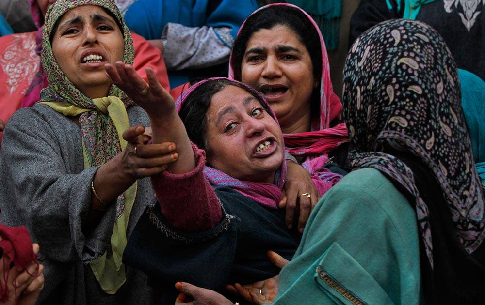 Unidentified women try to comfort a wailing relative, of Ghulam Nabi, a rural body head of a pro-Indian party, during a joint funeral procession of Ghulam and his son Firdous Ahmad at Batgund village, some 40 kilometers (25 miles) south of Srinagar.