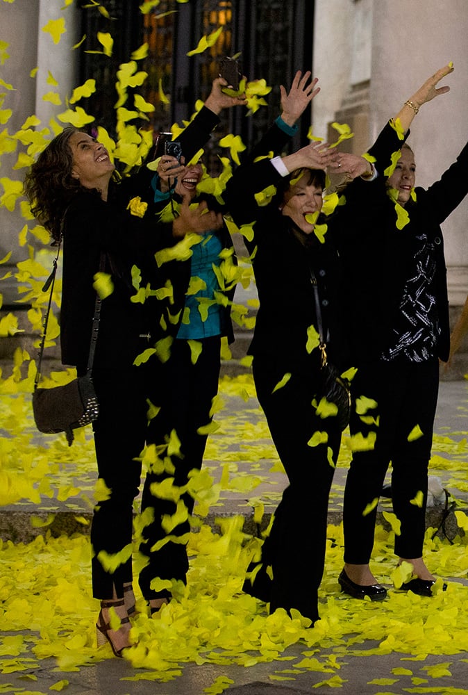 Guests play with yellow paper butterflies as they leaving an homage to Colombian Nobel Literature laureate Gabriel Garcia Marquez outside the Palace of Fine Arts in Mexico City.