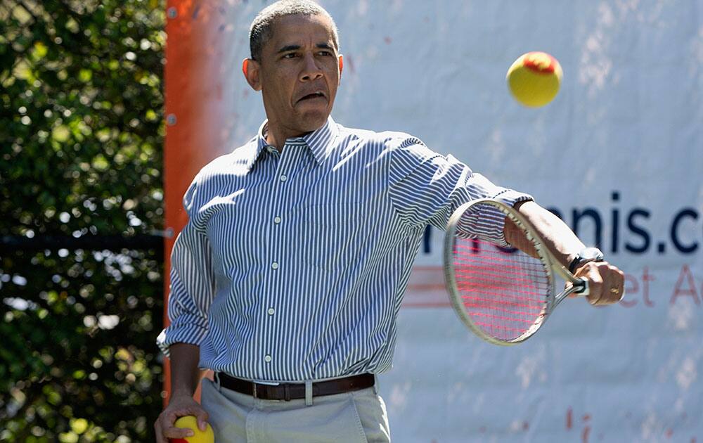 President Barack Obama plays tennis during the annual White House Easter Egg Roll, on the tennis court on the South Lawn of the White House in Washington. 