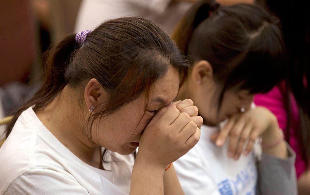 Relatives of Chinese passengers onboard the Malaysia Airlines Flight 370, cry during a meeting in Beijing.