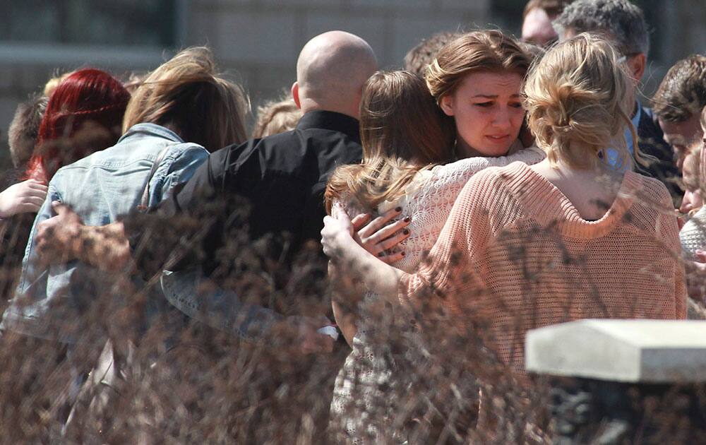 Mourners console each other after the funeral of stabbing victim Kaiti Perras in Calgary, Canada. Perras, who was 23, was one of five young people killed last week in an attack at a party marking the end of classes at the University of Calgary.