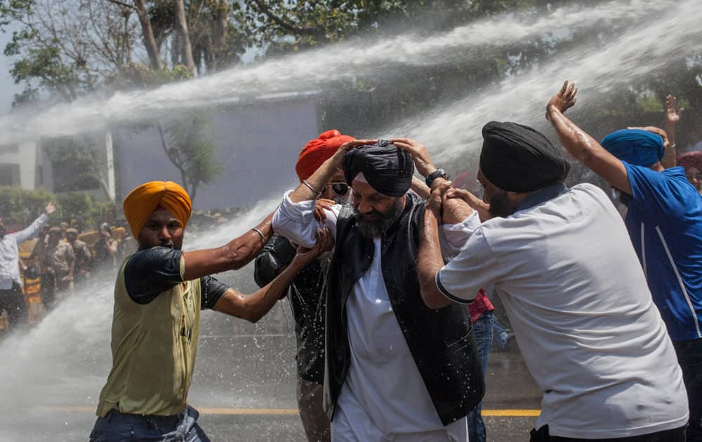 n elderly Sikh man is helped by other protesters as they face water canon during a demonstration against Congress party leader and former chief minister of Punjab state Captain Amarinder Singh for his recent remarks on the country’s 1984 anti-Sikh riots, in New Delhi, India.