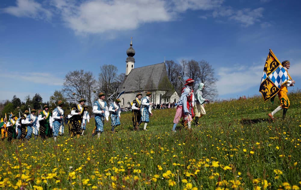 Local residents of the region wearing traditional costumes walk through a meadow to get blessing for men and beasts at the St. George church, in Traunstein, southern German.