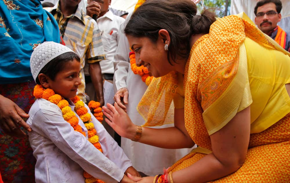 India`s main opposition Bharatiya Janata Party (BJP) candidate Smriti Irani, right, talks to a young Muslim boy at an election rally in Amethi, India.