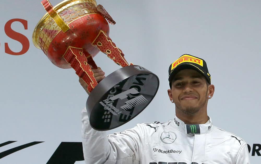 Mercedes driver Lewis Hamilton of Britain holds his champion trophy during the prize presentation on the podium after the Chinese Formula One Grand Prix at Shanghai International Circuit.