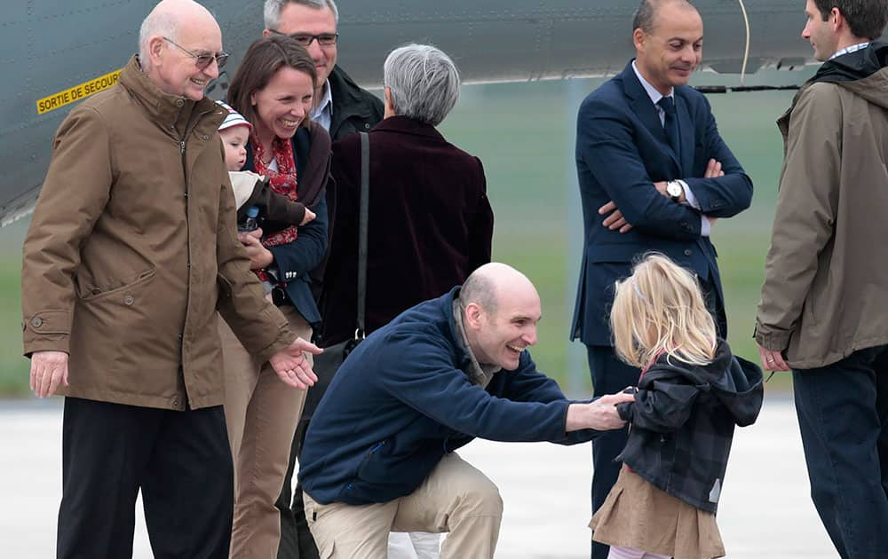 Released French hostage Nicolas Henin, center, meets his daughter upon his arrival at the Villacoublay military airbase, outside Paris.