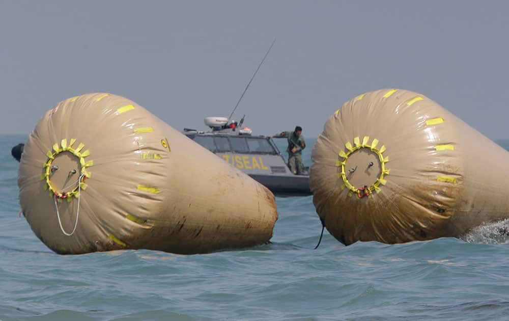 A South Korean Navy Seal member looks at the water while working to rescue missing passengers believed to have been trapped in the sunken ferry Sewol near the buoys which were installed to mark the vessel in the water off the southern coast near Jindo, south of Seoul, South Korea.