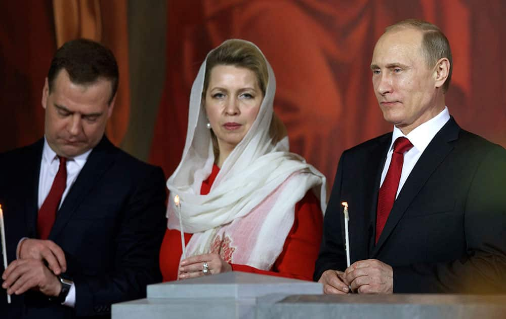 Russian President Vladimir Putin, right, Prime Minister Dmitry Medvedev, left, and his wife Svetlana attend the Easter service in Christ the Savior Cathedral in Moscow, Russia.