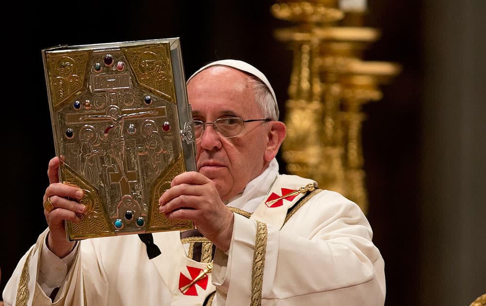 Pope Francis holds the Holy Gospel as he celebrates the Easter vigil service in St. Peter`s Basilica, at the Vatican.