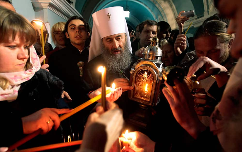 Ukrainian Orthodox believers, lights candles with fire which was delivered to the Ukrainian capital from the Church of the Holy Sepulcher in Jerusalem`s Old City, traditionally believed to be the burial place of Jesus Christ, after the ceremony of the Holy Fire, during the Easter service in the Kyiv-Pechersk Lavra church (Cave Monastery) in Kiev.