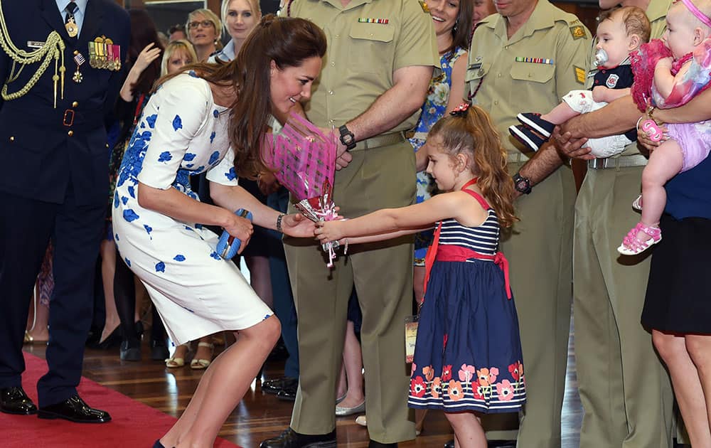 Kate, the Duchess of Cambridge, receives a bouquet of flowers from Tahlia McCabe as she meets with families of service personnel at RAAF Base Amberley, near Brisbane Australia.
