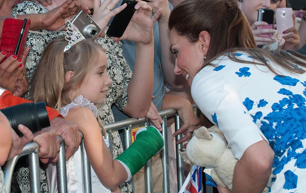 Kate, the Duchess of Cambridge, right, meets a young member of the public after attending a reception at the Brisbane Convention & Exhibition Centre, in Brisbane, Australia.