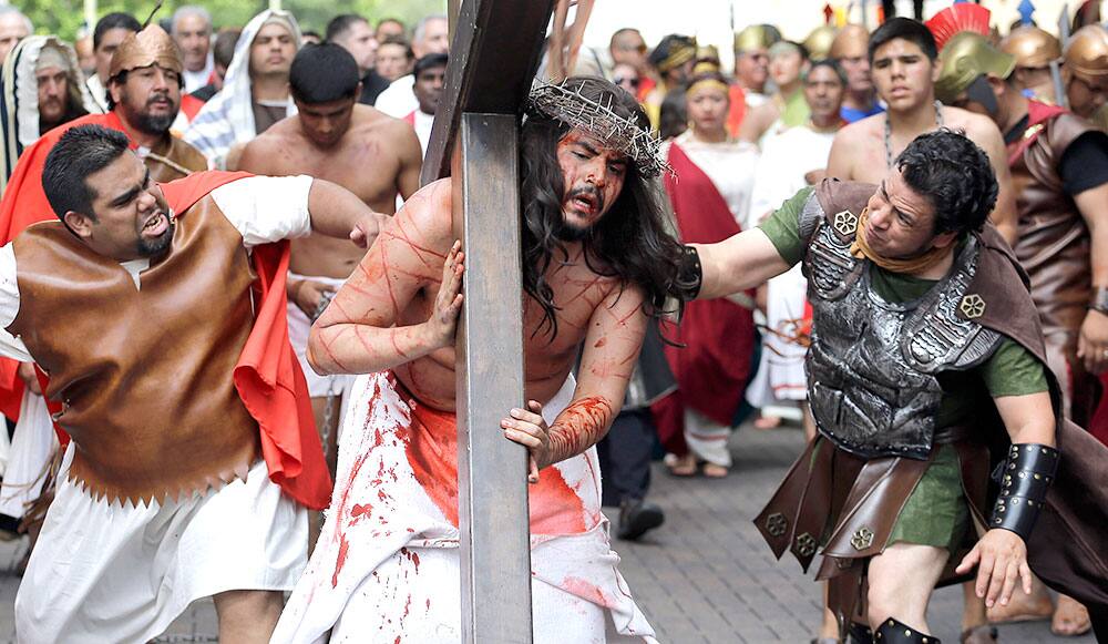 Jose Nina, is whipped as he carries a cross playing the part of Jesus in a passion play and procession, in downtown San Antonio. More than 100 actors take part in the Good Friday tradition.