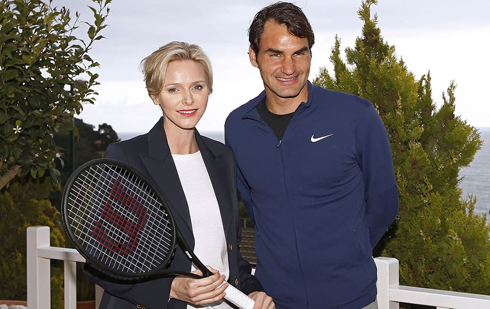 Princess Charlene of Monaco, left, and Swiss tennis player Roger Federer, right, pose for photographers during the Monte Carlo Tennis Masters tournament in Monaco.