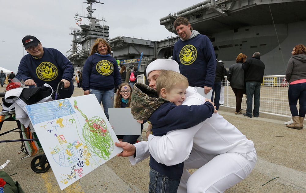 Kollia Safford, from Delhi N.Y., hugs his godfather, Communications Specalist, Christopher Payne, after he disembarked from the nuclear aircraft carrier Harry S. Truman at Naval Station Norfolk in Norfolk, Va.