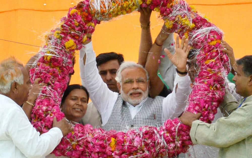 BJP’s PM candidate Narendra Modi is garlanded at an election campaign rally in Etawah.