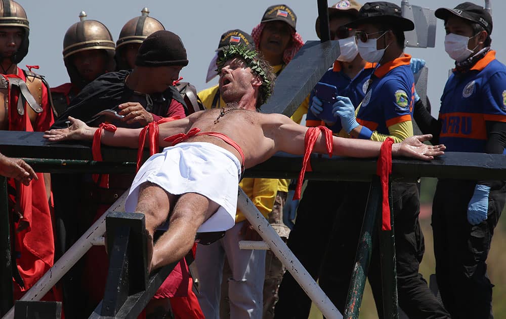 Danish national Lasse Spang Olsen, a 48-year-old filmmaker, grimaces as he is nailed to a cross to re-enact the crucifixion of Jesus Christ in San Juan village, Pampanga province, northern Philippines.