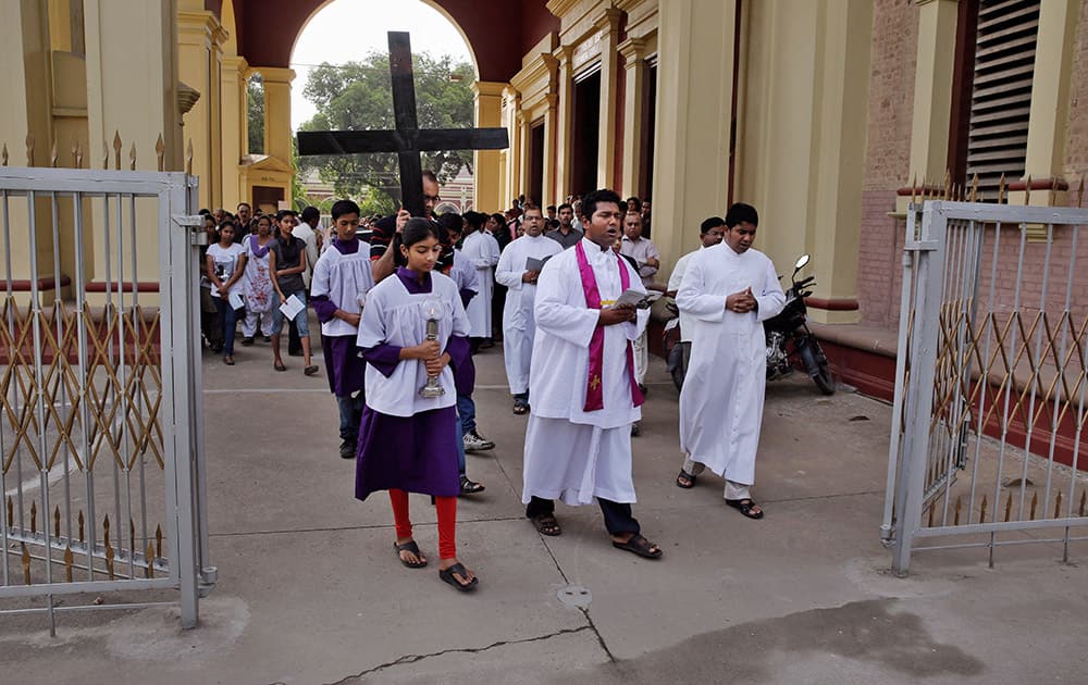 A Christian devotee carries a huge wooden cross as he participates in Good Friday procession at the St. Joseph cathedral in Allahabad.