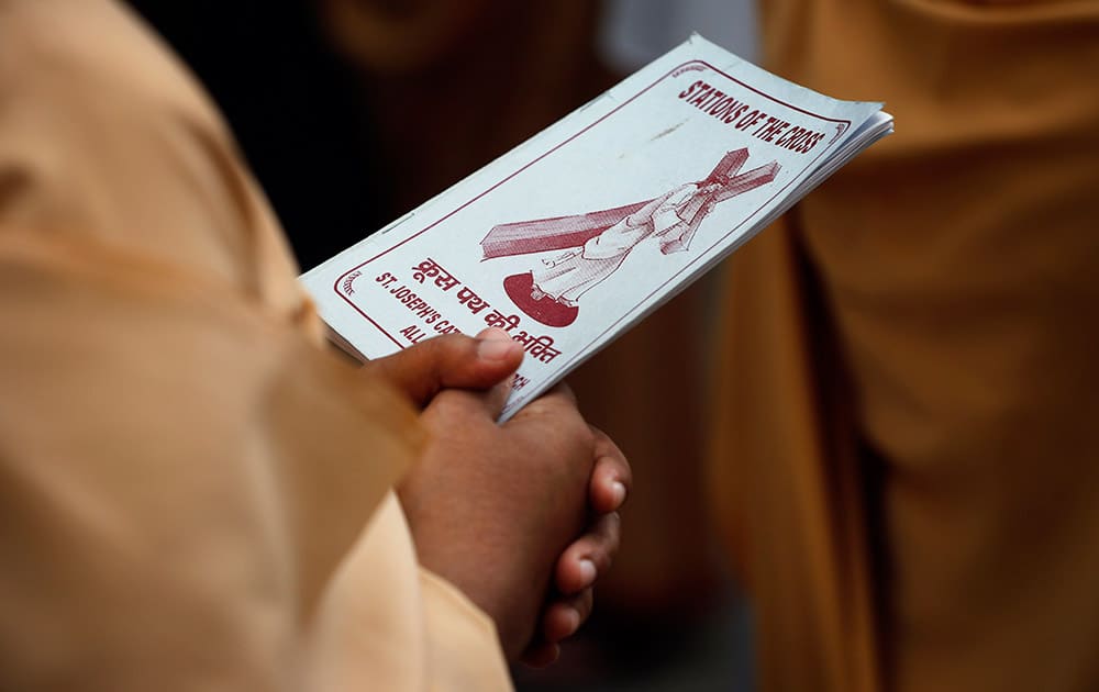 A Christian devotee holds onto a prayer book during Good Friday mass at the St. Joseph cathedral in Allahabad.