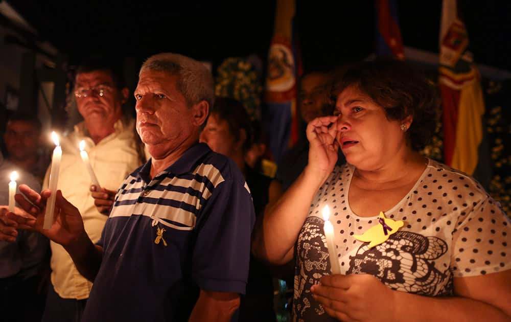 Graciela Fernandez, right, holds a candle in front of the Gabriel Garcia Marquez Museum, at the house were he was born in Aracataca, Colombia.