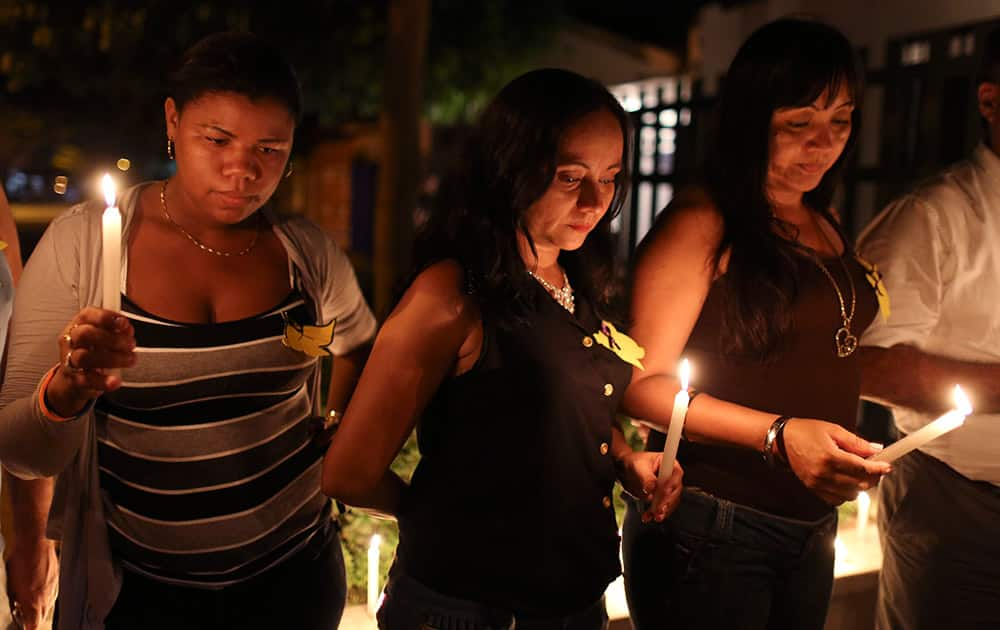 Women hold candles during a vigil in front of the Gabriel Garcia Marquez Museum, at the house were he was born in Aracataca, Colombia.