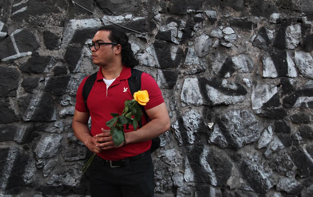 Miguel Guerra, a fan of Colombian author Gabriel Garcia Marquez, stands with flowers outside the funeral home where the body of Garcia Marquez was taken in Mexico City.