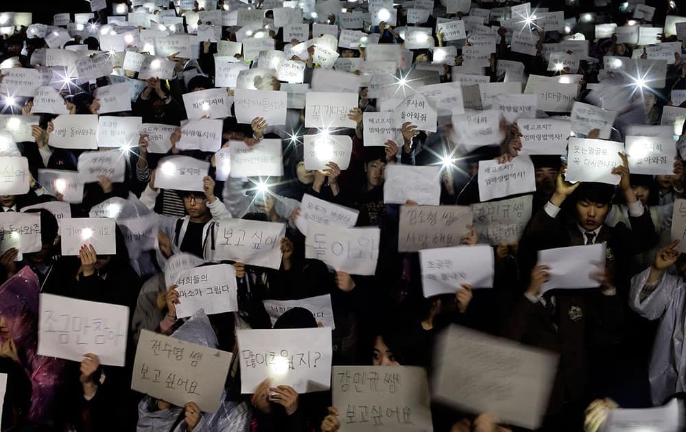 Danwon High School students hold papers with messages such as `come back,` `miss you,` `love you` and `don`t loose your hope` for their friends who are missing after Wednesday`s ferry disaster at the school yard in Ansan, South Korea.