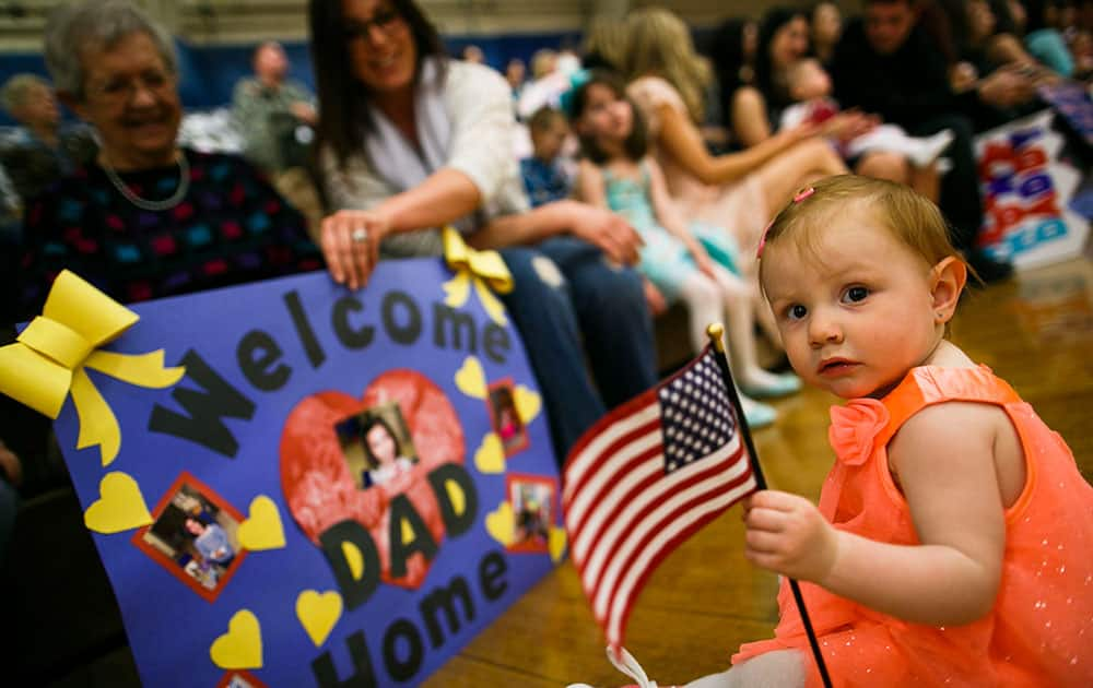 Brie Brock, 15 months, grasps an American flag in her hands as she and her family wait for the return of Staff Sgt. Scott Brock during the homecoming ceremony.