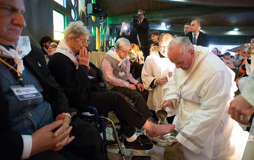 In this picture made available by the Vatican newspaper L` Osservatore Romano, Pope Francis washes the foot of a woman at the Don Gnocchi Foundation Center in Rome.